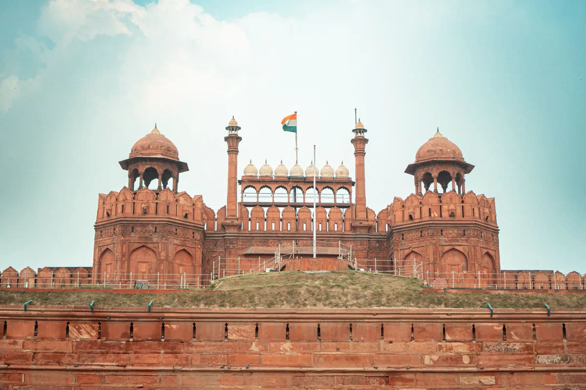 The Lahori Gate of the Red Fort in Delhi: red sandstone towers and domed pavilions, with the Indian flag above