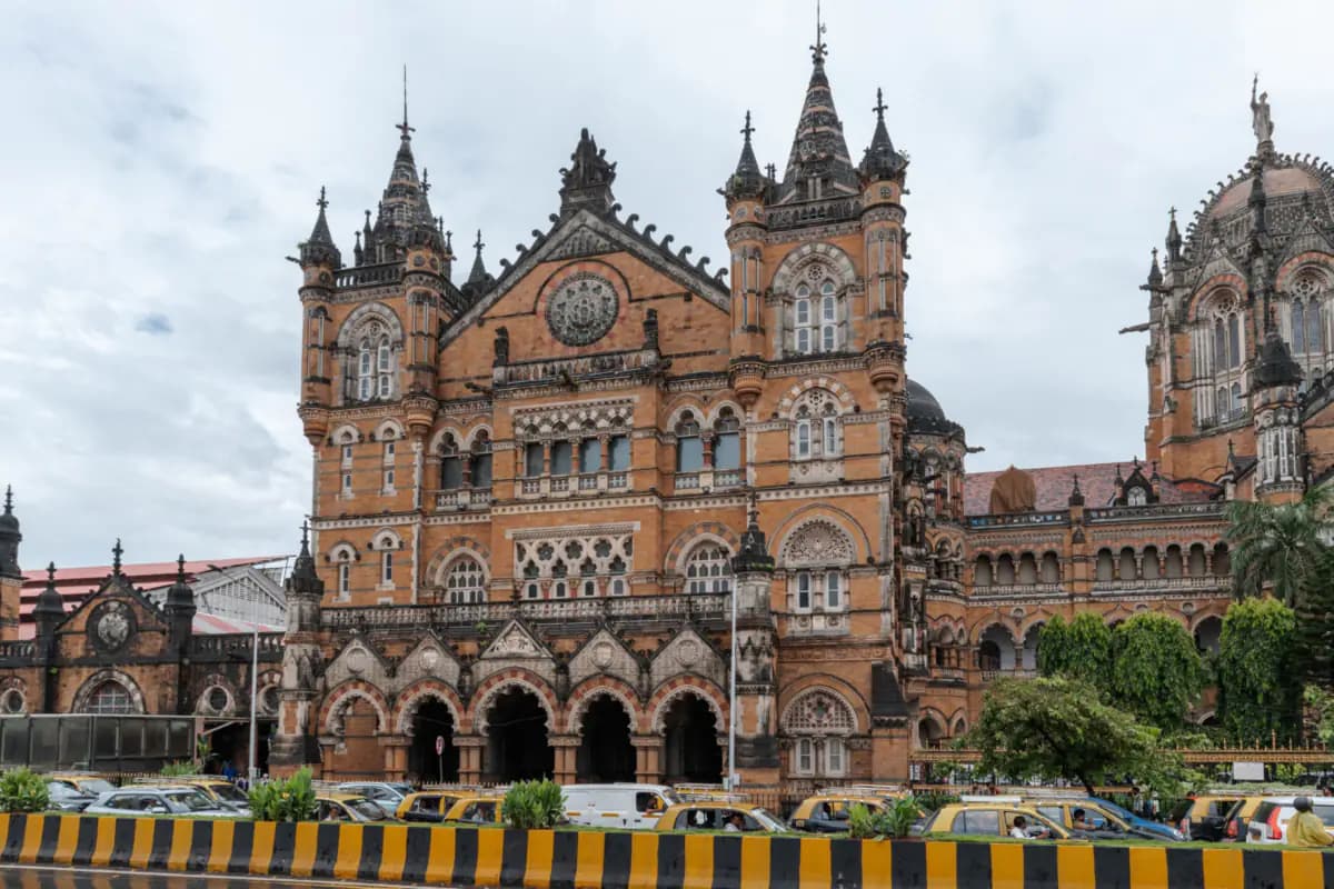 The Gothic facade of Chhatrapati Shivaji Maharaj Terminus in Mumbai, with spires and arches above a row of taxis